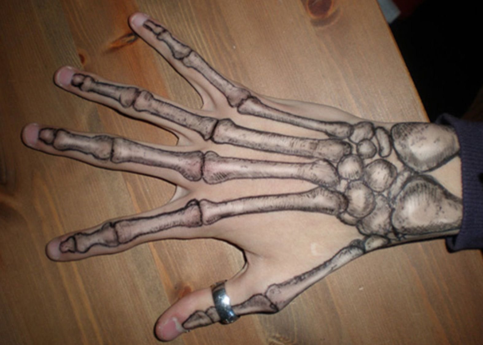 Скелет на руке черной ручкой